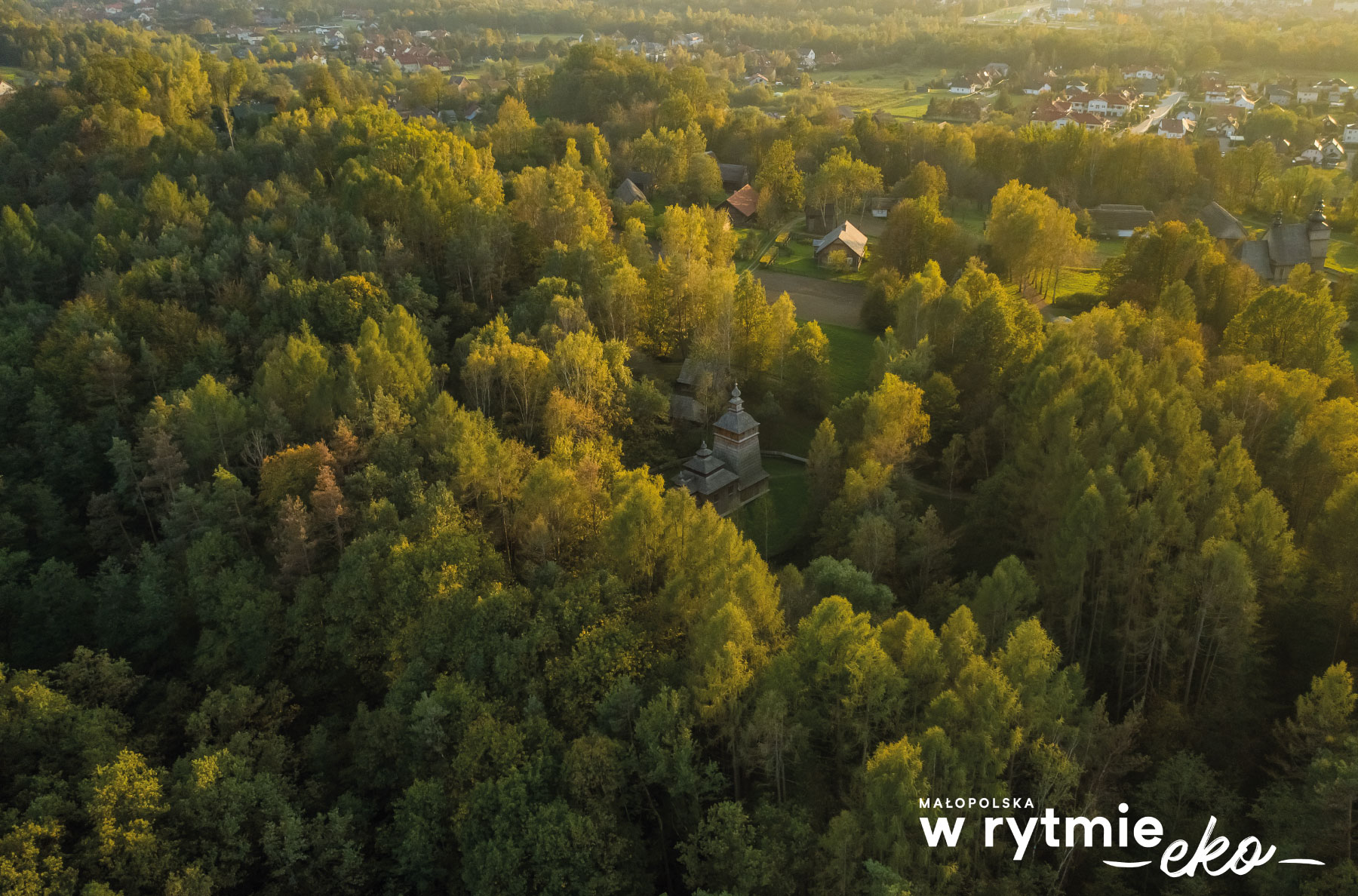 widok z lotu ptaka na drzewa a wśród nich malutki kościół