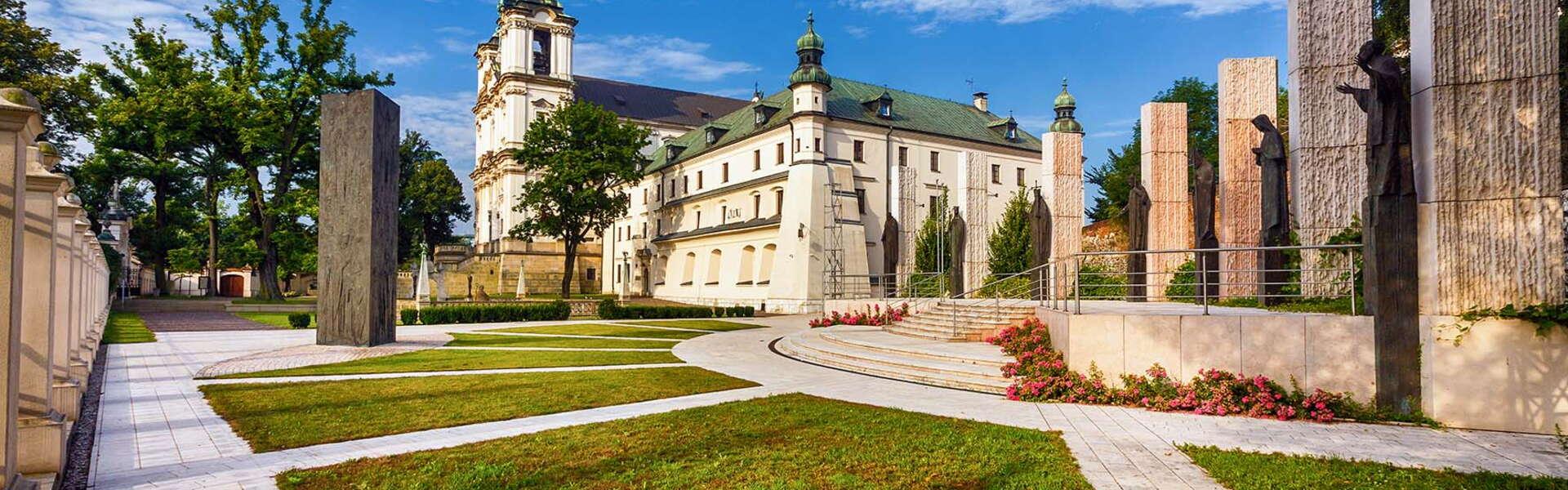 Ein Klostergebäude in einem grünen Garten.